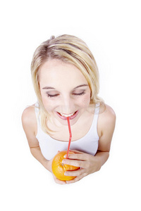一个女人用稻草喝橘子