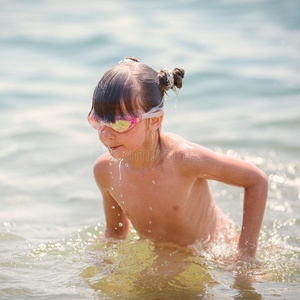 蓝色的大海背景上的游泳池玩具年轻漂亮的女孩在比基尼橡胶在热带的