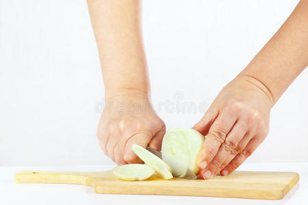 女性手拿刀在砧板上切洋葱