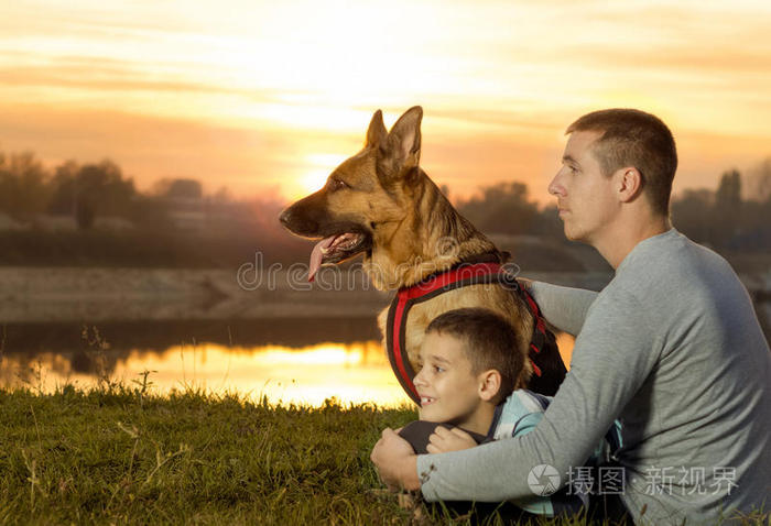 父子俩和德国牧羊犬在大自然中观看日落