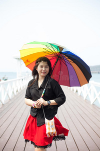 亚洲女子黑色衬衫撑着伞站着。
