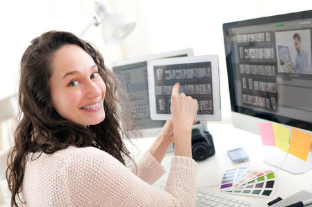 年轻女摄影师在平板电脑上挑选照片