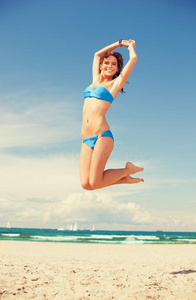 海滩上快乐的跳跃女人