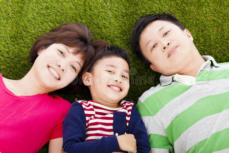 幸福的父母和儿子躺在草地上