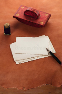 皮革桌上的复古墨水笔墨水壶和复古照片