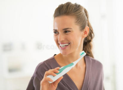 快乐的年轻女子在浴室刷牙
