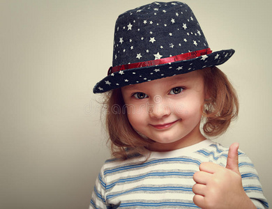 戴蓝色帽子微笑的小女孩伸出大拇指