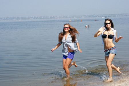 快乐的年轻女性跑过沙滩