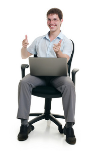 这位商人坐在扶手椅上用的笔记本电脑