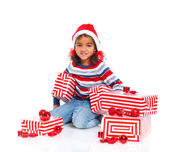 小女孩在圣诞老人的帽子与礼品盒
