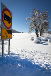 交通标志警告的雪和冰，阳光和雪域天与