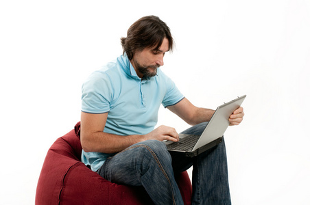 一男子用光背景上的一台笔记本电脑