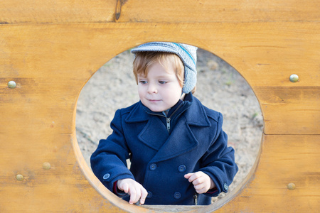 蓝色外套上的冬日美丽蹒跚学步的男孩