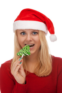 年轻的金发女人在糖果的圣诞老人帽子