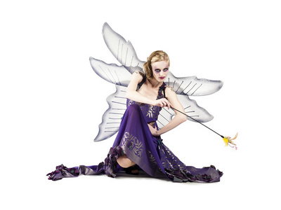 挥舞棒持有的魔杖的童话打扮漂亮的女人照片