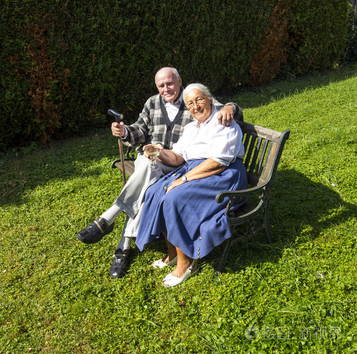 老人夫妇坐在他们的花园和享受生活