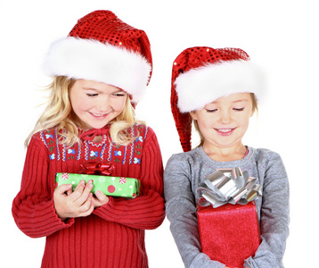 两个孩子举行穿上圣诞老人的帽子的礼物