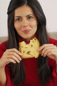 美丽的年轻女子吃甜圣诞 bread.woman 吃甜点。