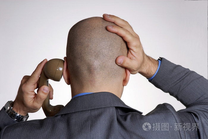 担心成人光头头男人从电话上的后视图