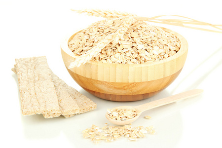 木碗充分的麦片用木勺 小穗和孤立在白色的燕麦饼干