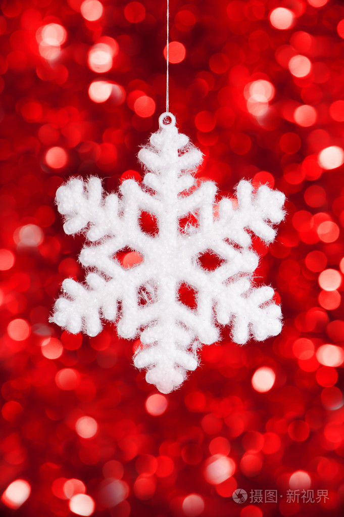 红色散景背景上的一个大雪花玩具