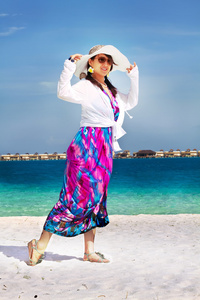 时尚美丽亚洲女孩玩水在马尔代夫海滩附近