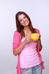 年轻的 womanholding 黄色茶杯子