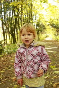 漂亮的小女孩在秋天的森林中
