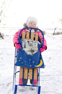 快乐的小女孩，举行她冬天雪橇