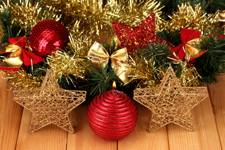 圣诞蜡烛和装饰品的木制背景上的红色和金色颜色组成