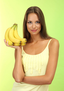 美丽的年轻女子，与香蕉 绿色背景