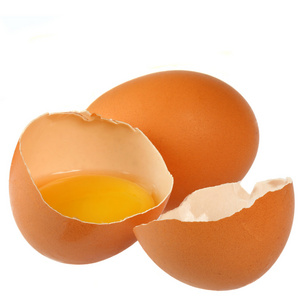 在白色背景上的棕色鸡蛋。一个鸡蛋被打破