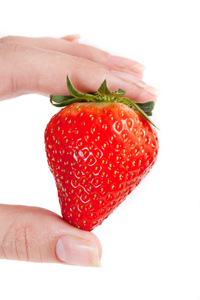 一个新鲜草莓在女性手中的孤立在白色