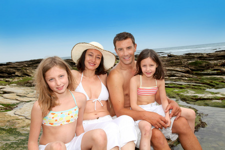 4 坐在沙滩上的幸福家庭