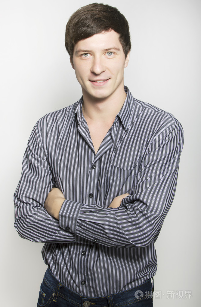 英俊的年轻商业男人在工作室里微笑