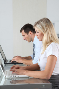 男人和女人在便携式计算机上办公室工作