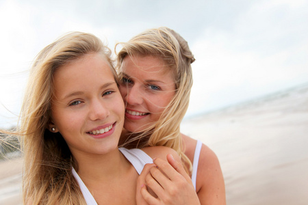 金发碧眼的女人和年轻的女孩，在沙滩上