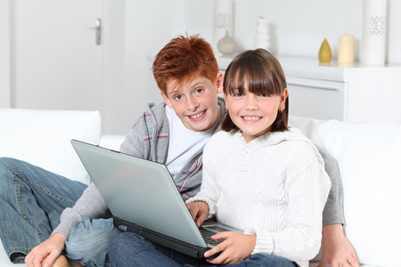 年轻的男孩和女孩在家里用的笔记本电脑