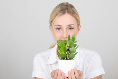 持有绿色的植物的女人肖像