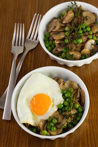 煎的鸡蛋和蘑菇放在盘子和刀叉豆