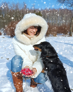 快乐的女孩与狗在冬季公园