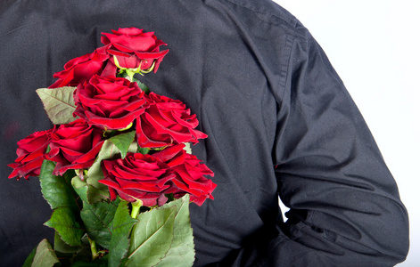 一个男人举在他背后的红玫瑰的图片照片