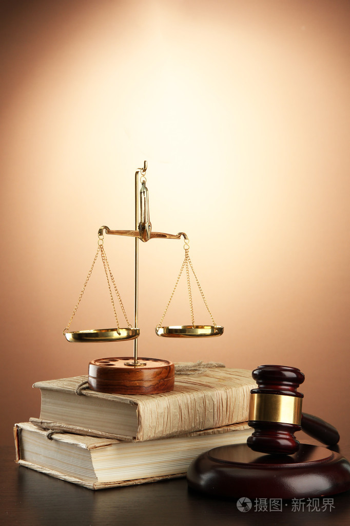 金秤的正义木槌和棕色背景的书