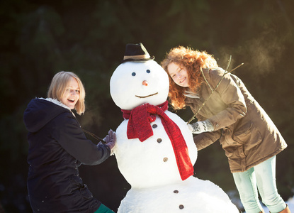 两个年轻妇女建立一个雪人