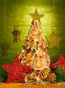 干柠檬与装潢，闪耀绿色背景上的漂亮的圣诞树