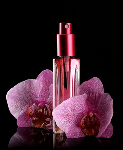 在漂亮的瓶子里和兰花花，在黑色背景上的女性香水