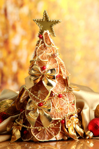 干柠檬与装潢，在黄色背景上的漂亮的圣诞树