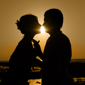 在日落时接吻情侣的 sillhouette