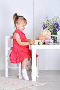 一个小女孩玩娃娃和菜