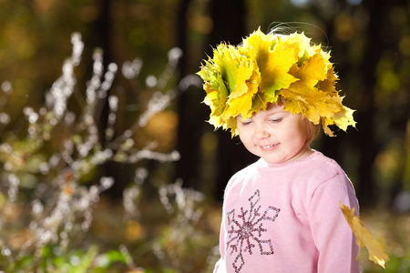 漂亮的小女孩在一个花圈枫叶叶子在秋季前